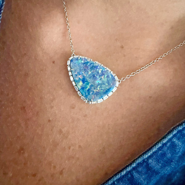Lumen Opal Pendant featuring a blue iridescent teardrop opal framed by diamonds, worn on a model.