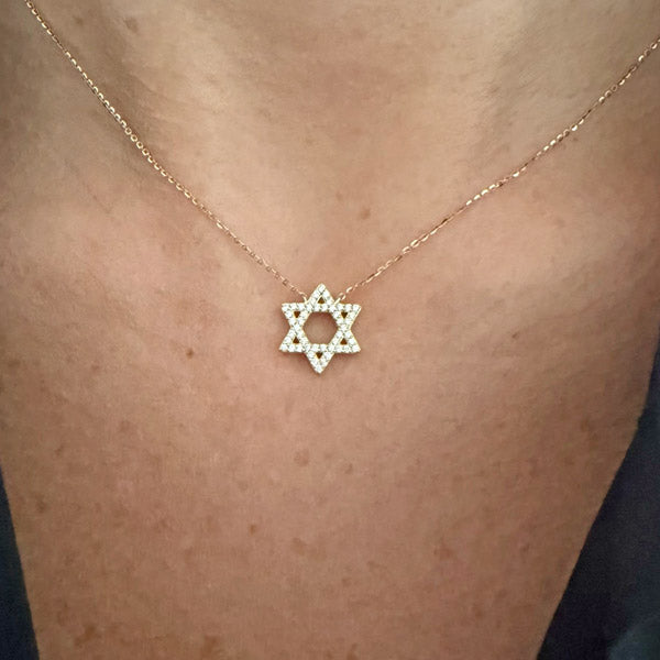 Magen diamond pendant featuring a diamond-set six-pointed star on a fine gold chain, worn at the neckline.