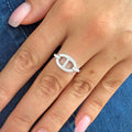 Close-up of a sculptural open oval diamond ring in white gold on a woman's hand, featuring a pavé diamond open-circle design for refined everyday wear.